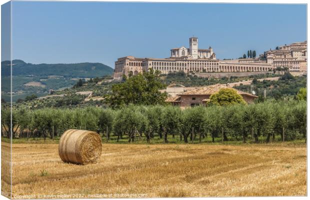 Hay roll overlooked by the Basilica di San Francesco D'Assisi, Umbria, Italy Canvas Print by Kevin Hellon