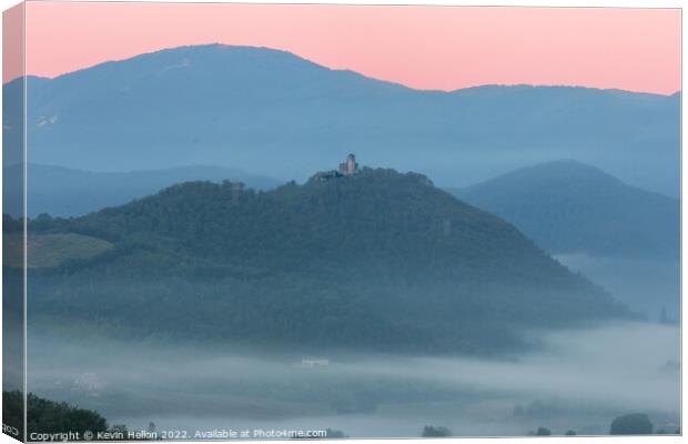 Hilltop castle surrounded by early morning mist Canvas Print by Kevin Hellon