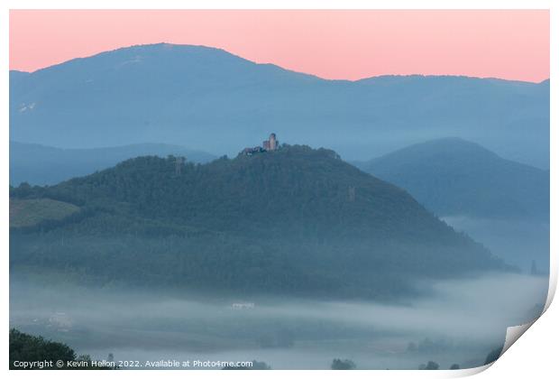 Hilltop castle surrounded by early morning mist Print by Kevin Hellon