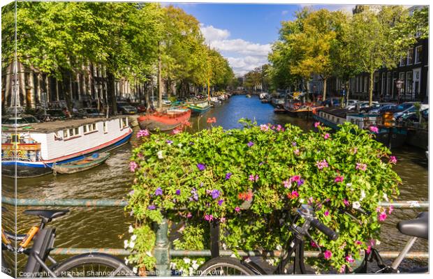 Bike, flowers on bridge over canal in Amsterdam Canvas Print by Michael Shannon