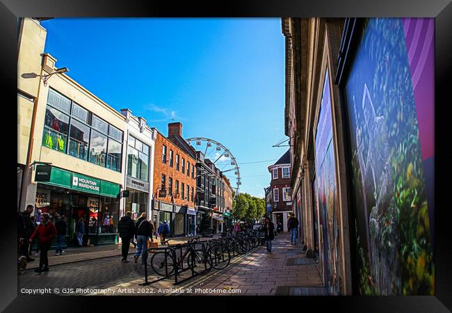 Bikes Buildings and a Wheel Framed Print by GJS Photography Artist