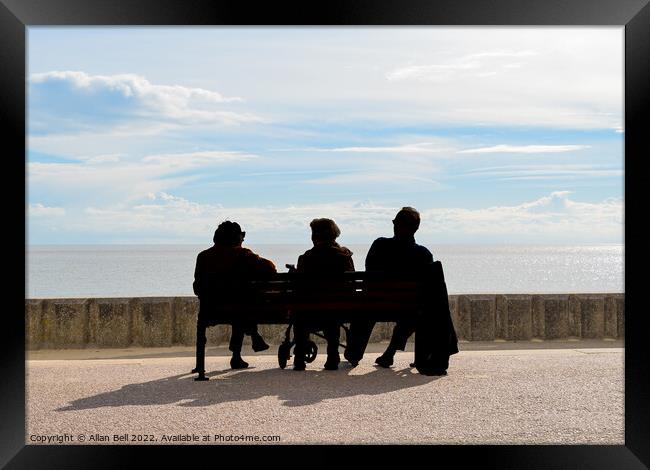 Three peoplepeople sitting on a bench looking out  Framed Print by Allan Bell