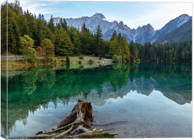 Picturesque Blue Lake Fusine with Julian Alps in Background. Canvas Print by Maggie Bajada