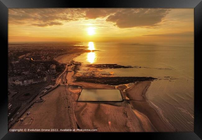 A sunset over a body of water Framed Print by Evolution Drone
