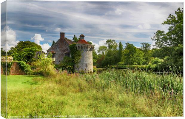 Ruined English moated Castle surrounded by meadow  Canvas Print by John Gilham