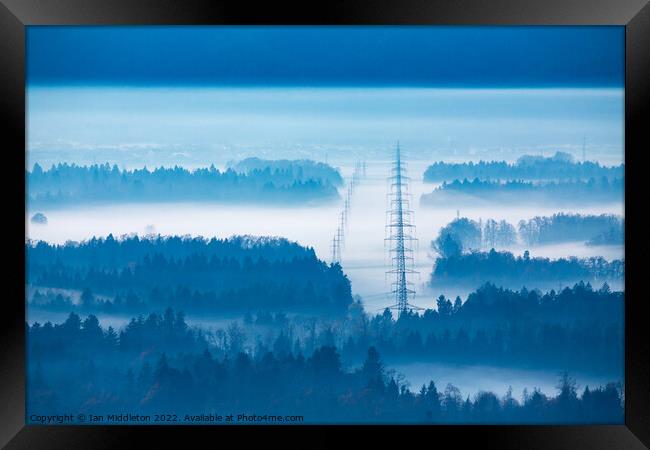 Electricity pylons in the mist. Framed Print by Ian Middleton