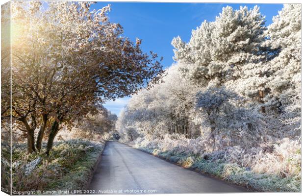 Winter rural road with frozen ice trees Canvas Print by Simon Bratt LRPS