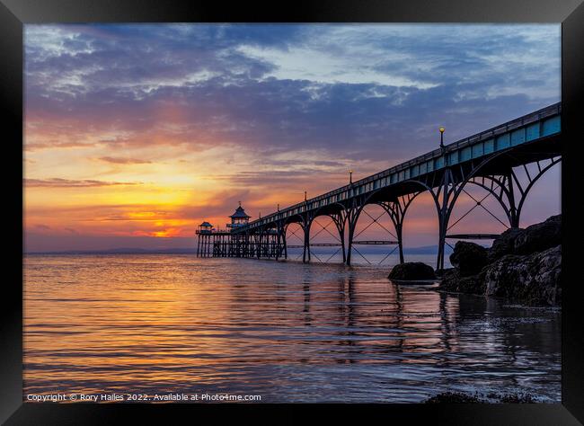 Pier at sunset with golden sunlight Framed Print by Rory Hailes