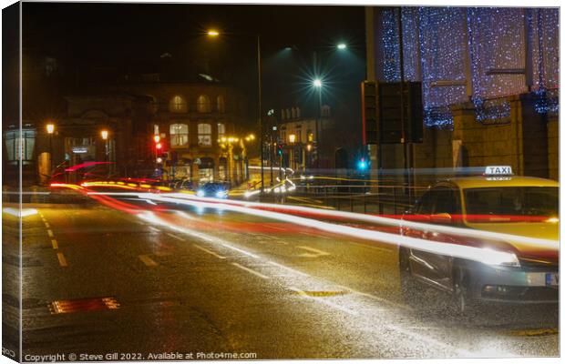 During the Evening of a Rainy Night, a Yellow Taxi Travels Along a Wet Road. Canvas Print by Steve Gill