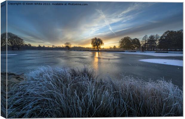 Rising sun over the blue frozen ice Canvas Print by Kevin White