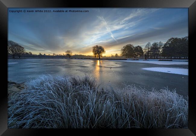Rising sun over the blue frozen ice Framed Print by Kevin White
