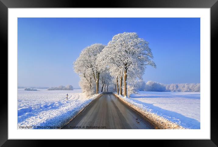 View of a snow-covered country road in winter with sunshine and  Framed Mounted Print by Michael Piepgras