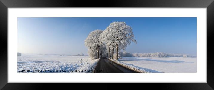 View of a snow-covered country road in winter with sunshine and  Framed Mounted Print by Michael Piepgras