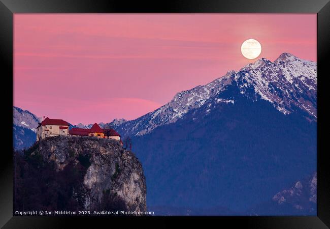 Full moon rising at sunset beside the castle at Lake Bled Framed Print by Ian Middleton