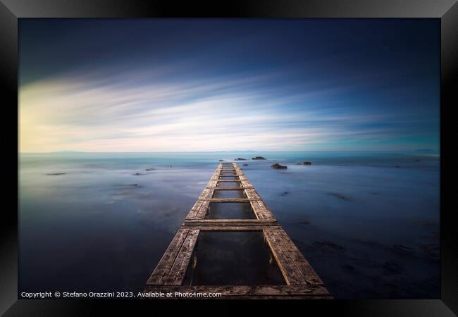 Wooden pier remains in a blue sea. Long Exposure. Framed Print by Stefano Orazzini