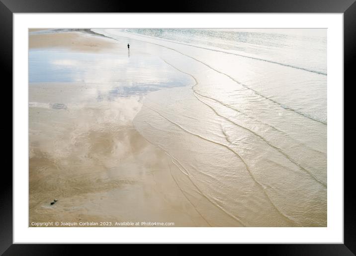 A lone retired person walks away on the sand of a beach in winte Framed Mounted Print by Joaquin Corbalan