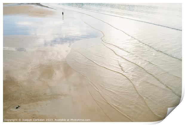 A lone retired person walks away on the sand of a beach in winte Print by Joaquin Corbalan
