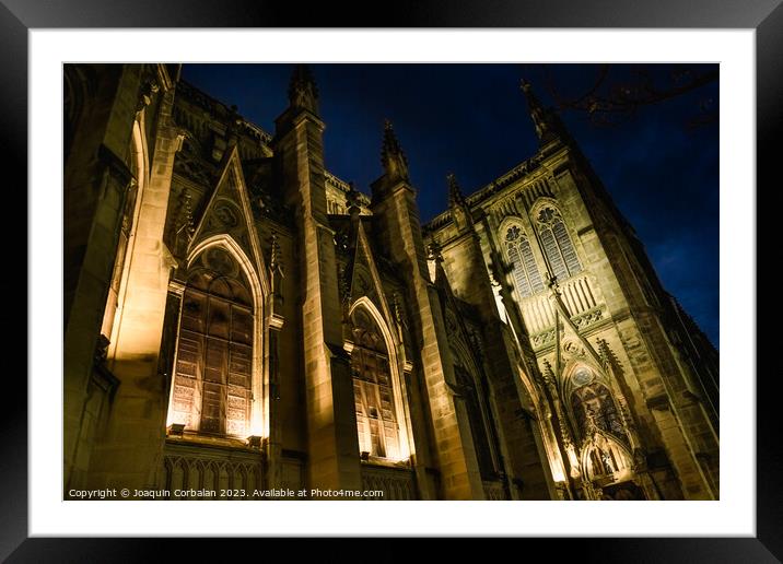 The cathedral of San Sebastian is illuminated at night in a ghos Framed Mounted Print by Joaquin Corbalan