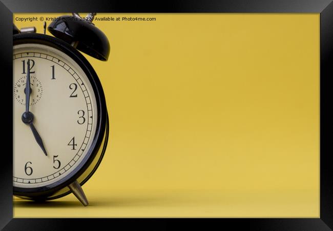 Analog alarm clock displaying five o'clock on a yellow background with copy space Framed Print by Kristof Bellens