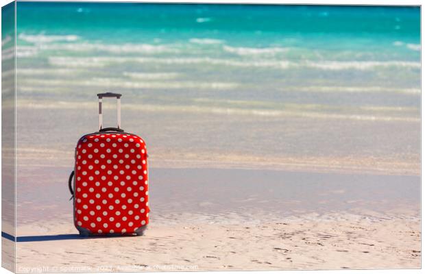 Red polka dot travel luggage on sand beach Canvas Print by Spotmatik 