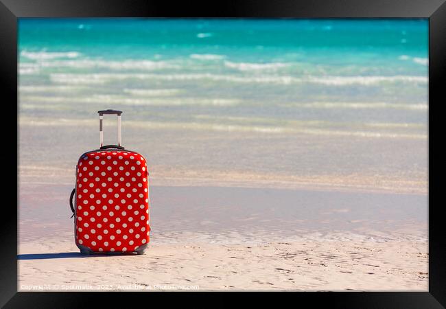 Red polka dot travel luggage on sand beach Framed Print by Spotmatik 
