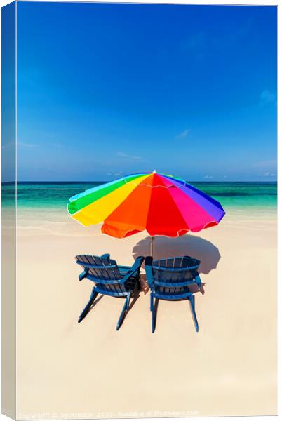 Parasol  beach chairs on white tropical sandy shoreline Canvas Print by Spotmatik 