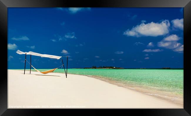 Hammock swaying in the breeze over white sands  Framed Print by Spotmatik 