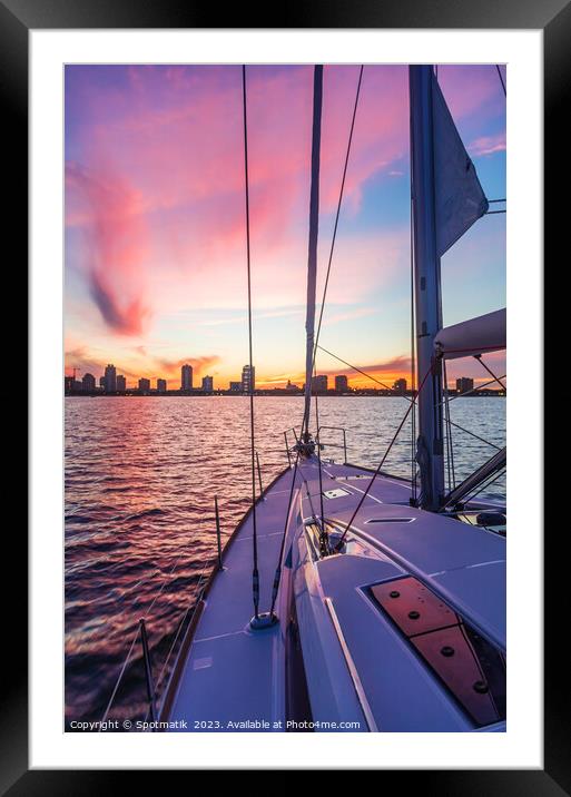 Sailing luxury yacht at sunset with cityscape view Framed Mounted Print by Spotmatik 