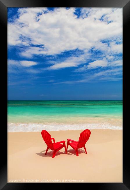 Red chairs on sandy beach by ocean Bahamas Framed Print by Spotmatik 
