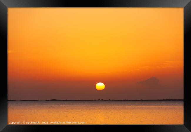 Tropical ocean view with orange sky at sunset Framed Print by Spotmatik 