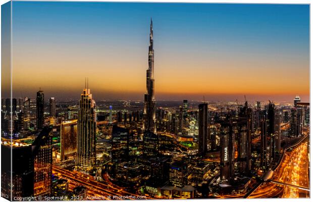 Aerial illuminated Dubai at sunset Burj Khalifa UAE Canvas Print by Spotmatik 