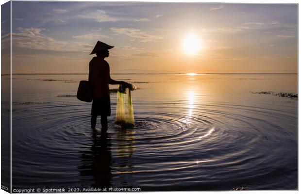 Silhouette Balinese male fishing Indonesian coastline at sunrise Canvas Print by Spotmatik 