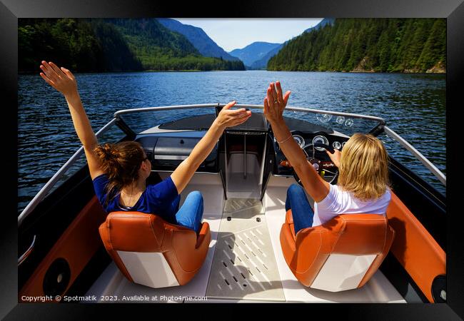 Female partners speeding across Vancouver mountain lake Framed Print by Spotmatik 