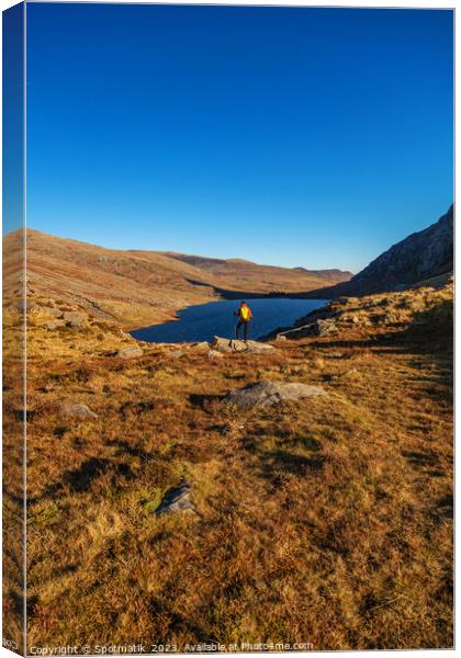 Lake in rural landscape with female backpacker Snowdonia Canvas Print by Spotmatik 