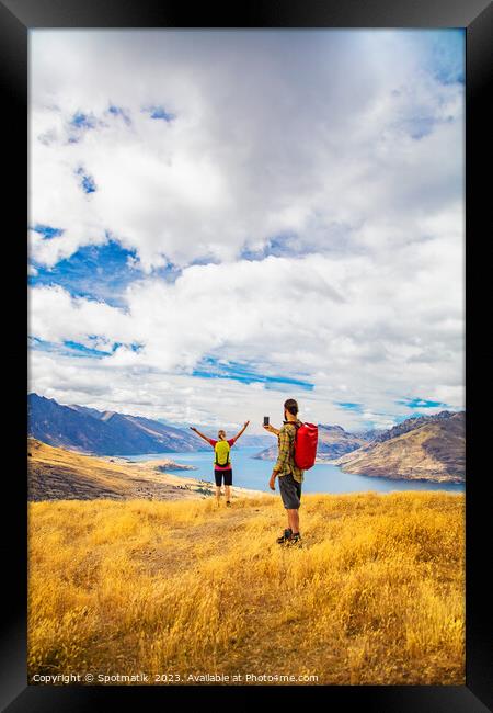 Young male taking picture of female friend Queenstown Framed Print by Spotmatik 