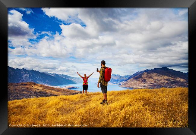 Backpacking young couple taking smartphone picture Lake Wakatipu  Framed Print by Spotmatik 