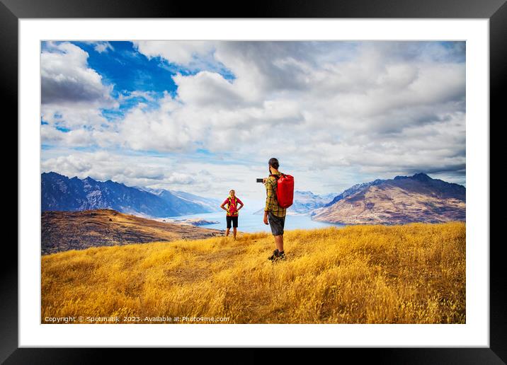 Hiking male taking smartphone travel pictures of girlfriend Framed Mounted Print by Spotmatik 