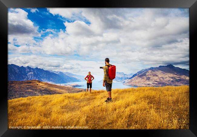 Hiking male taking smartphone travel pictures of girlfriend Framed Print by Spotmatik 