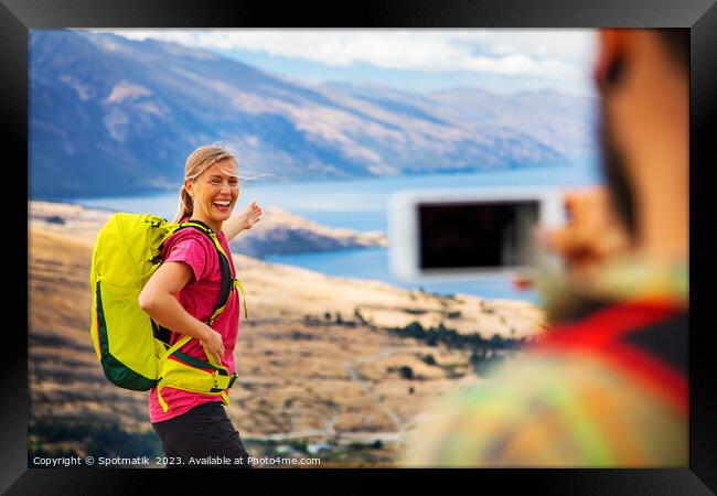 Young male taking picture of happy female Queenstown Framed Print by Spotmatik 