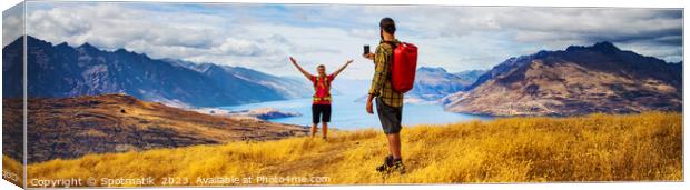 Panorama of young backpacking couple taking smartphone photo  Canvas Print by Spotmatik 