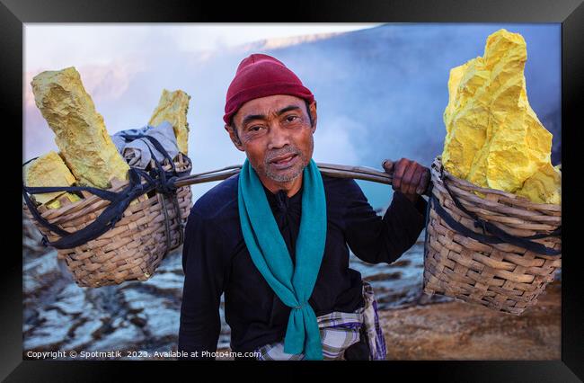 Indonesian worker manually carrying sulphur blocks from volcano  Framed Print by Spotmatik 