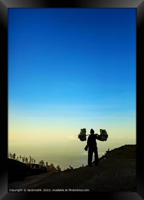 Indonesian worker carrying sulphur blocks from volcano Rim  Framed Print by Spotmatik 