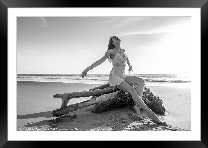 Young beach girl enjoying sun sitting on driftwood  Framed Mounted Print by Spotmatik 