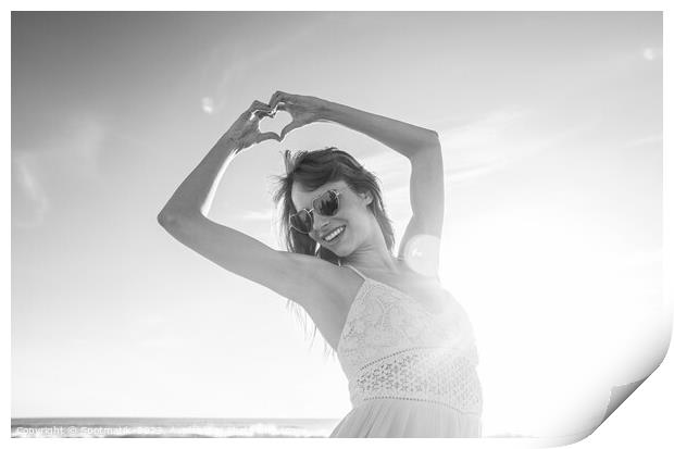 Bohemian girl showing heart sign dancing on beach Print by Spotmatik 