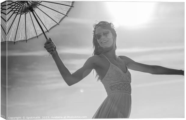 Young American female dancing on beach with parasol Canvas Print by Spotmatik 