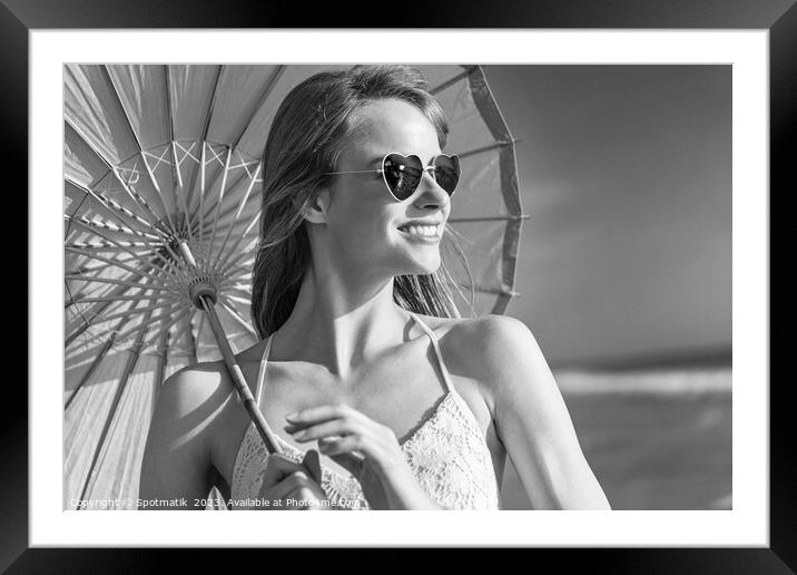 Smiling American hippy chic with parasol on beach Framed Mounted Print by Spotmatik 