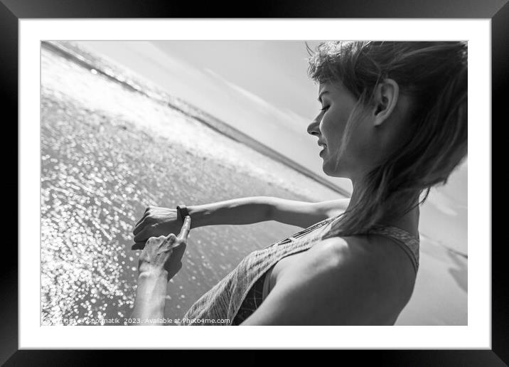 Caucasian female on ocean edge checking sports watch Framed Mounted Print by Spotmatik 