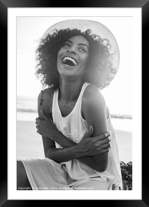 Laughing Afro American female wearing hat on beach Framed Mounted Print by Spotmatik 