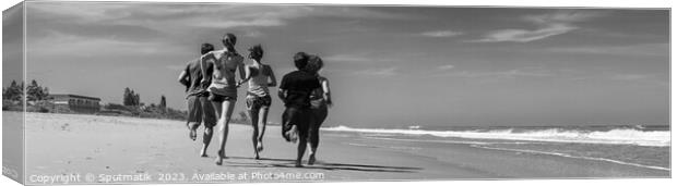 Panoramic view of friends jogging together on beach Canvas Print by Spotmatik 