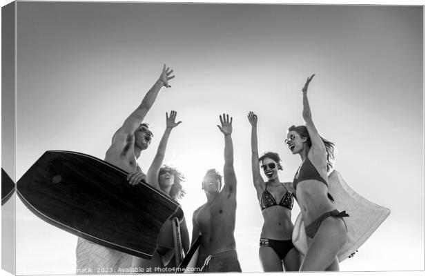 Friends in swimwear carrying bodyboards celebrating fun activity Canvas Print by Spotmatik 